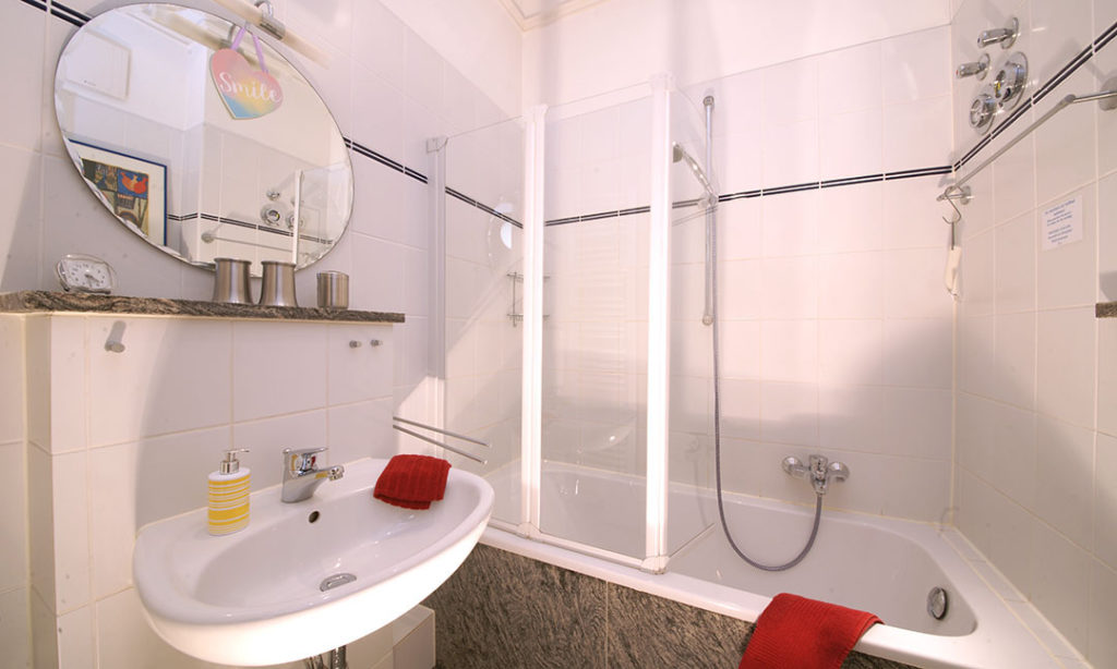 Badezimmer mit Waschbecken, Wanne und WC sowie vielen nützlichen Accesoires
